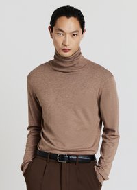 Brauner Rollkragenpullover aus einem weichen Strickstoff, mit einer körperbetonten Passform, langen Ärmeln und gerippten Details am Kragen.