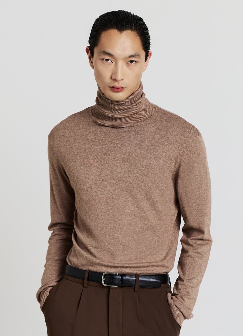 Brauner Rollkragenpullover aus einem weichen Strickstoff, mit einer körperbetonten Passform, langen Ärmeln und gerippten Details am Kragen.