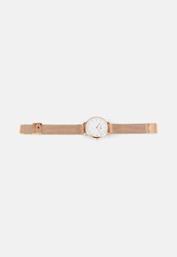 Montre avec bracelet en maille rose gold, dotée d'un cadran rond blanc, affichant des index horaires minimalistes, une lunette lisse et un fermoir à clip.