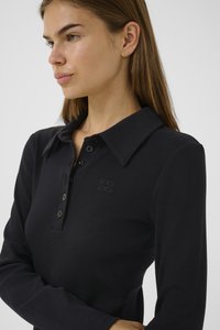 Black, ribbed long-sleeve polo shirt featuring a buttoned placket and a collar. Subtle logo on the left chest. Soft texture.