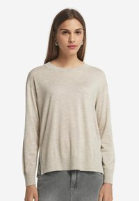Hellbeige gestrickter Pullover mit Rundhalsausschnitt, langen Ärmeln und einer lockeren Passform, ausgestattet mit gerippten Manschetten und einem leicht verlängerten hinteren Saum.