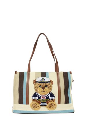Borsa tote a righe beige e marroni con manici marroni, decorata con un orsetto di tessuto indossante un completo da marinaio blu navy e cappello ricamato con la scritta "Rue Madam Paris".