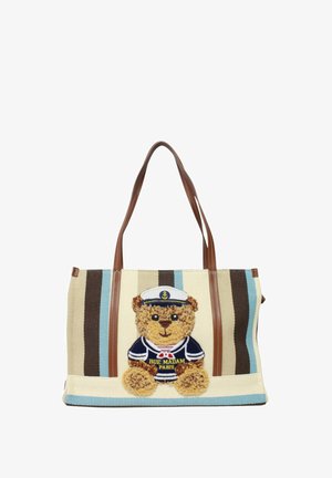 Borsa tote a righe beige e marroni con manici marroni, decorata con un orsetto di tessuto indossante un completo da marinaio blu navy e cappello ricamato con la scritta "Rue Madam Paris".