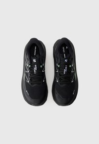 Black athletic shoes with a mesh upper, white accents, and a thick rubber sole. Features laces and branding on the tongue.