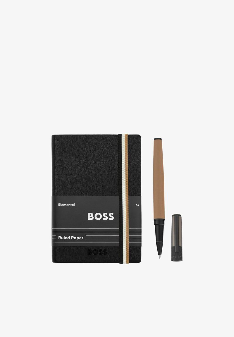 Carnet A6 noir ligné avec élastique et un stylo marron dont le capuchon est retiré, présenté sur un fond blanc.