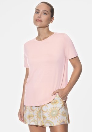 Pink short-sleeve t-shirt with a round neckline, paired with white shorts featuring a sun and moon pattern in yellow and gold accents.