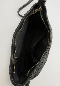 Musta kudottu käsilaukku, jossa on sileä pinta, useita lokeroita ja kultaiset vetoketjut. Vuorattu mustalla kankaalla, varustettu olkahihnalla.