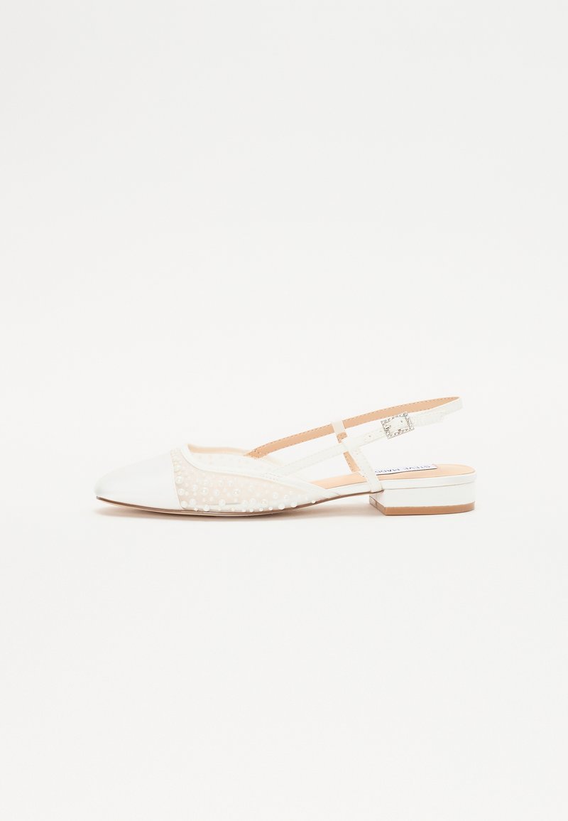 Zapato slingback blanco con punta afilada, tejido texturizado que presenta pequeñas cuentas y un tacón bajo en bloque. Detalle de correa ajustable en el tobillo.