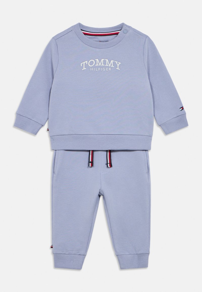 Sweatshirt bleu clair et pantalons de survêtement assortis en coton, avec un logo, des poignets élastiques et des accents rayés sur la ceinture.