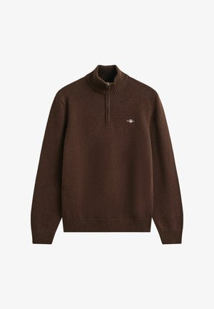 Ruskea neulepaita, jossa on korkea kaulus, puolivetoketjullinen muotoilu, resorikujat ja helma sekä pieni logo rinnassa. Pehmeä rakenne.