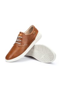 Zapatos de cuero marrón con parte superior texturizada y cordones blancos. Cuentan con una suela blanca en contraste y un patrón geométrico en la suela exterior.