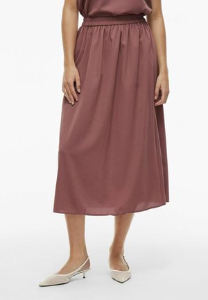 Jupe longue à taille élastique, fabriquée en tissu léger de couleur rose poudré, avec un design fluide et un léger éclat.