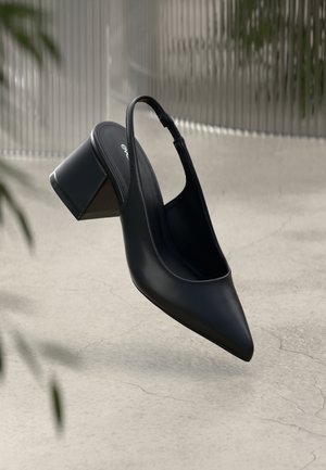 Black leather slingback heel with a pointed toe and a block heel. Smooth texture, minimal design, and adjustable ankle strap.