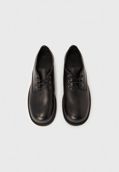 Scarpe nere in pelle con lacci, punta arrotondata, sei occhielli, finitura liscia e suola in gomma resistente.