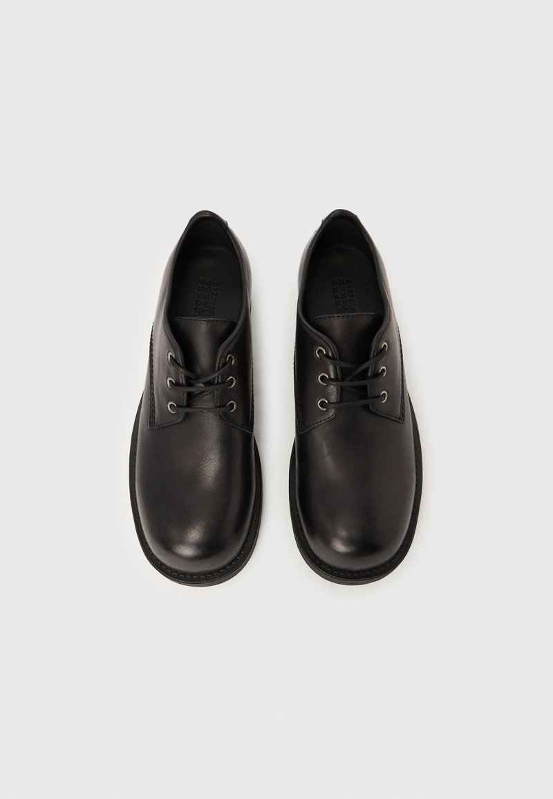 Chaussures à lacets en cuir noir avec un bout rond, dotées de six œillets, d'une finition lisse et d'une semelle en caoutchouc durable.