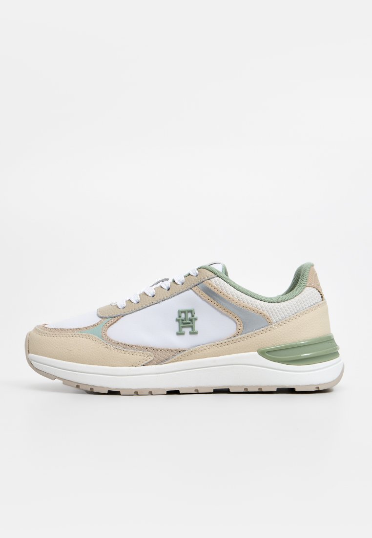Beige und weiße Sneakers mit grünen Akzenten, ausgestattet mit einem Mesh-Obermaterial, strukturierten Einsätzen, einer runden Zehenpartie und einer gepolsterten Sohle.