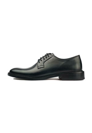 Black leather oxford shoe with a smooth finish, rounded toe, lace-up closure, and a low, textured rubber sole. Minimalistic design.