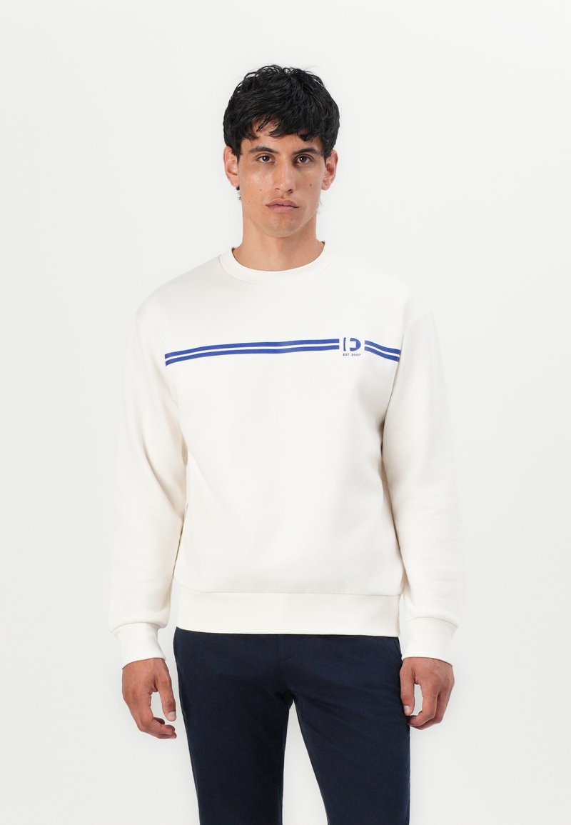 Cream-colored sweatshirt with a blue horizontal stripe and logo detail on the left chest. Features a crew neck and ribbed cuffs.