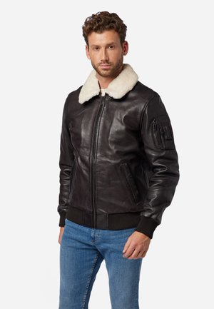 Schwarze Lederbomberjacke mit einem cremefarbigen Schafsfellkragen, gerippten Bündchen und einem Reißverschluss; verfügt über eine Seitentasche am Ärmel.