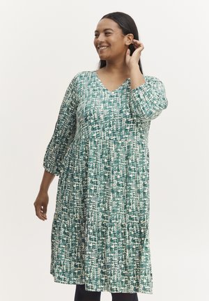 Grün-weißer gemusterter Kleid mit V-Ausschnitt, drei Viertelärmeln und gestuftem Rock. Aus leichtem Stoff mit lockerer Passform.