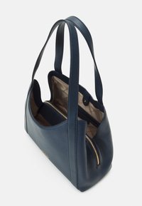 Mörkblå läderhandväska med dubbla handtag, beige vadderad inredning och en gyllene dragkedjeficka inuti.