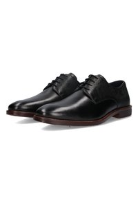 Chaussures habillées en cuir noir avec un bout lisse et des panneaux supérieurs texturés et tissés. Présente des lacets foncés et une semelle en cuir marron cousue.