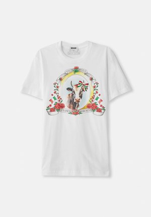 T-shirt en coton blanc avec un graphisme central d'une vache entourée de roses et de drapeaux italiens, avec un texte décoratif disposé en cercle.