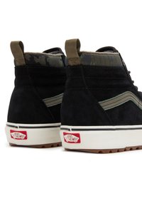 Černé semišové tenisky s vysokým svrškem, límec s maskáčovým vzorem, zelený proužek a bílá gumová podrážka s červenou nášivkou "VANS OFF THE WALL".