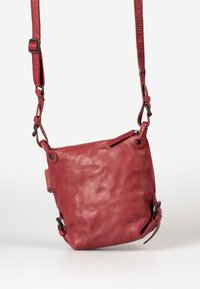 Rode leren schoudertas met een zachte textuur, ritssluiting en verstelbare riem met metalen accenten en stiksels.