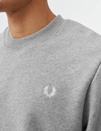 Felpa grigia con colletto a costine, caratterizzata da un piccolo logo di alloro ricamato in bianco sul petto. Tessuto morbido e vestibilità classica.