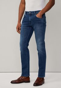 Dunkelblaue Slim-Fit-Jeans mit einem klassischen Fünf-Taschen-Design, aus Denim gefertigt, mit einer glatten Textur und einem mittelhohen Taillenbund.