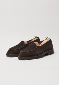 Brown suede loafers with rounded toe, contrasting stitch detail, pink lining, and gold heel lifts. Thick rubber sole for traction.