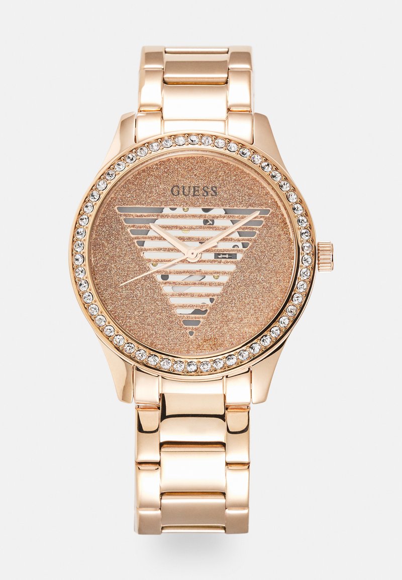Roségoldene Uhr mit einem dreieckigen glitzernden Zifferblatt, silbernem Logo und Kristall-Lünette. Metallarmband mit polierter Oberfläche.