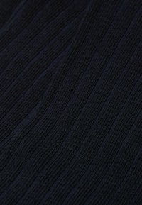 Ciemnoniebieska tkanina o fakturze z pionowym prążkowanym wzorem, miękkim wyglądzie i lekko elastycznym splotem. Brak widocznych akcentów lub elementów metalowych.