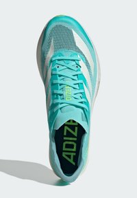 Scarpa sportiva turchese con tomaia in rete, strisce bianche e dettagli verdi. Presenta chiusura con lacci e colletto imbottito per il comfort.