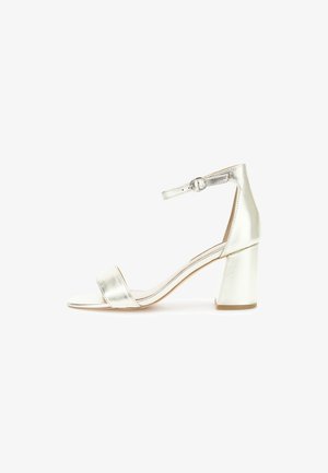 Sandalie cu toc înalt argintii din metal, cu toc bloc lat, vârf deschis, curea frontală unică și curea pentru gleznă cu închidere prin cataramă.