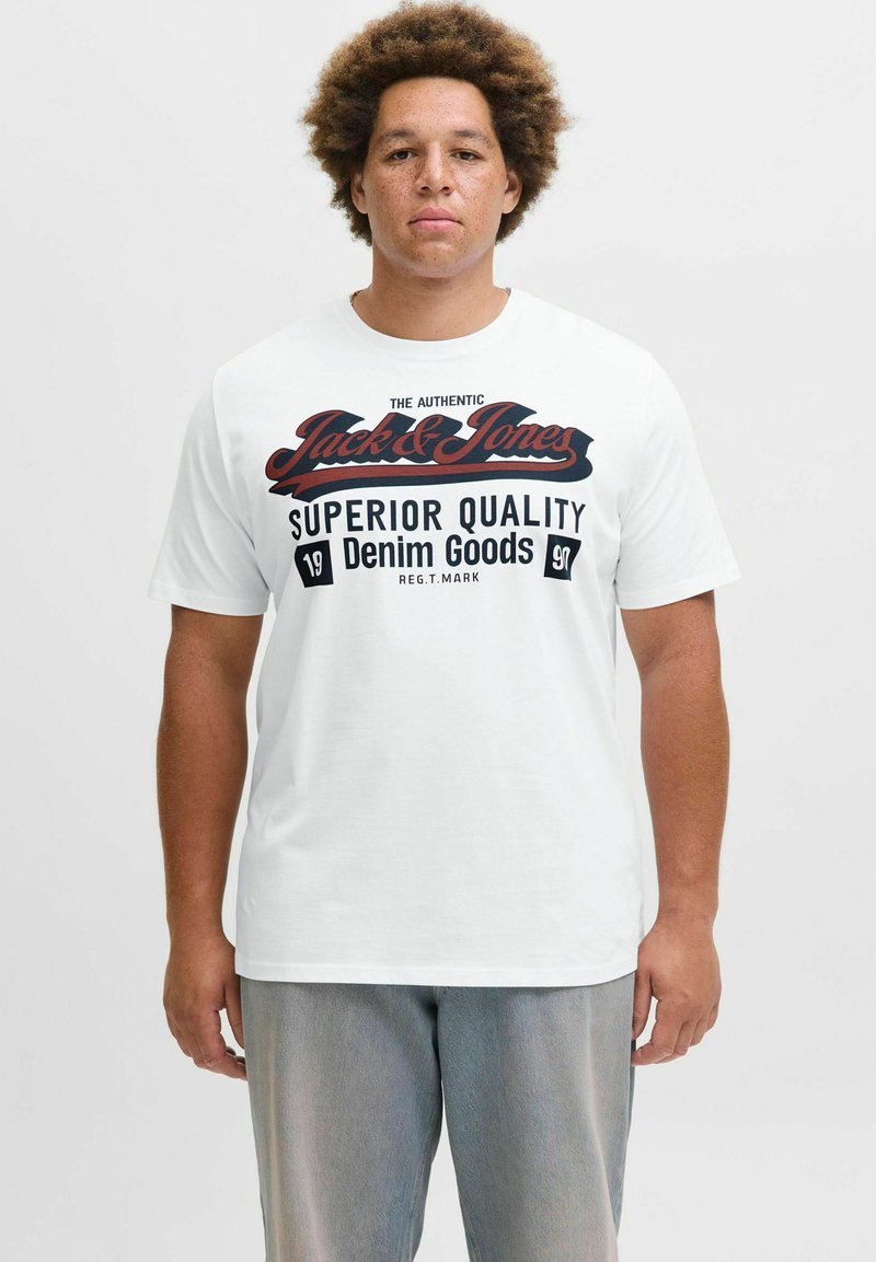 Hvid kortærmet t-shirt med sorte og røde tekstgrafikker, der står "Jack & Jones Superior Quality Denim Goods," med rund halsudskæring.
