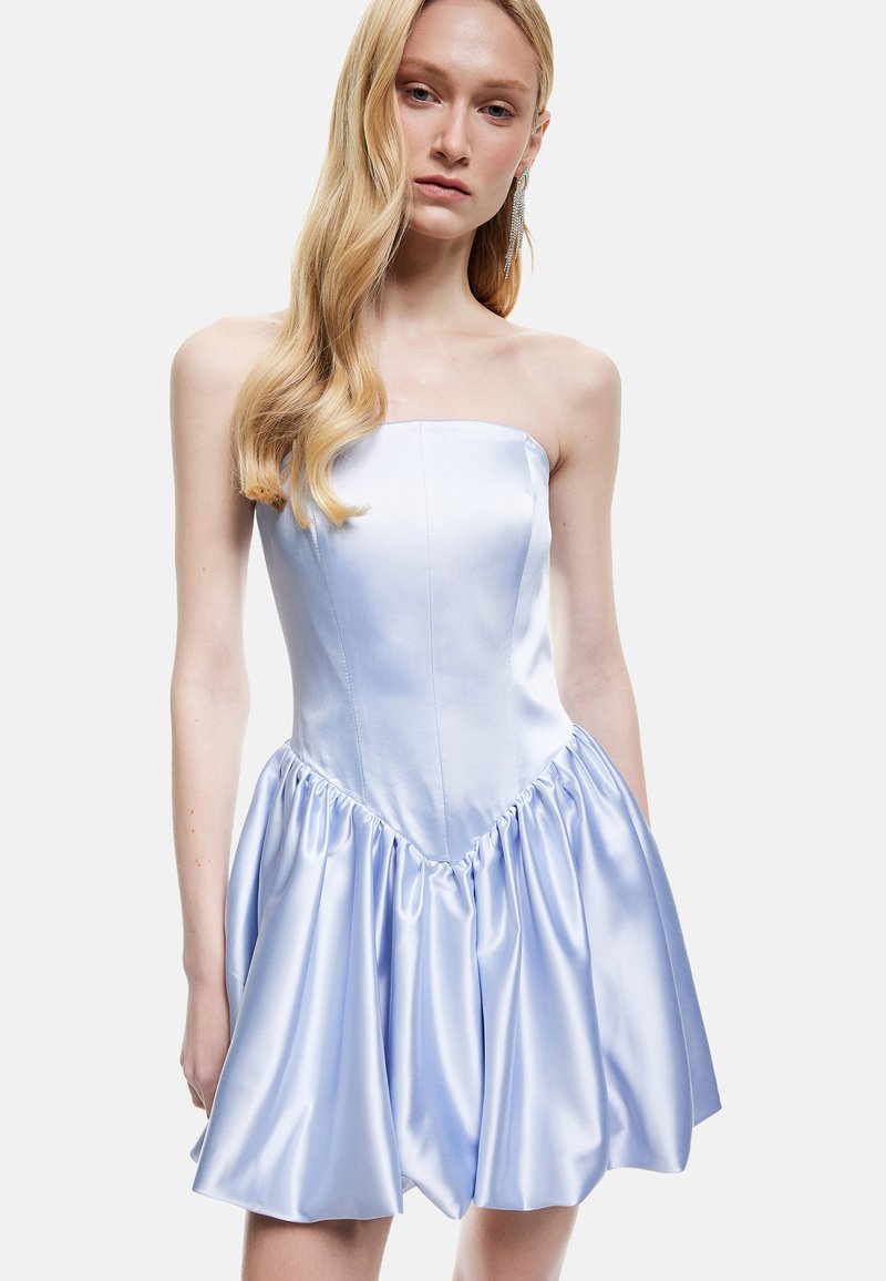 Strapless mini-jurk in lichtblauwe satijn. Aansluitend lijfje met naaddetails, uitlopende rok met geplisseerde textuur aan de zoom.