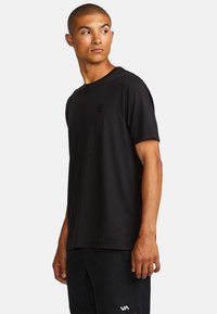 Schwarzes Kurzarm-T-Shirt aus glattem Stoff, mit Rundhalsausschnitt und kleinem erhabenem Logo auf der Brust.
