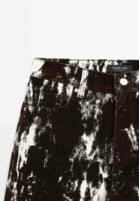 Jean taille haute noir et blanc délavé à l'acide, avec passants de ceinture, poche avant, bouton argenté et étiquette Massimo Dutti à l'intérieur de la ceinture.