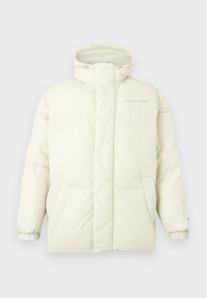 Chaqueta de plumas blanca con un cuello alto, textura acolchada y puños elásticos. Presenta dos bolsillos laterales y un sutil logotipo en el pecho.