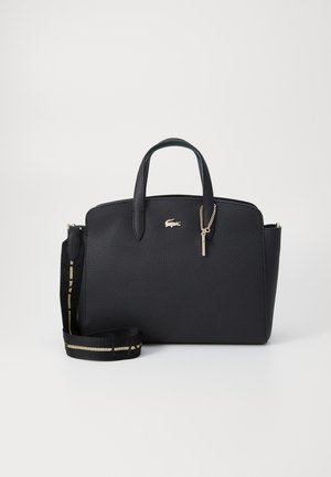 Sac à main en cuir noir texturé avec deux poignées, bandoulière amovible avec une bande dorée, et petit logo crocodile doré sur le devant.