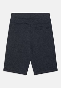 Mørkegrå shorts laget av myk stoff, med flat midje, baklomme. Rett snitt med knelengde og kantede kanter.