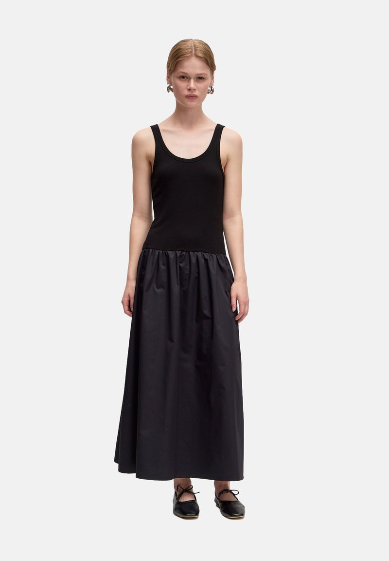 Zwart tankjurk met een aansluitende ribgebreide top en een vloeiende, geraffineerde satijnen rok, met een middenlengte ontwerp en een gladde textuur.