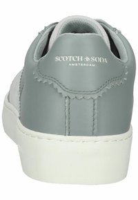 Gray leather sneaker with white sole, featuring a smooth finish and subtle stitching details. Logo on the back: "SCOTCH & SODA AMSTERDAM."