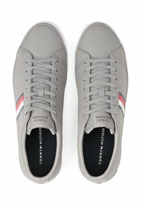 Sneakers in tela grigia con suole in gomma bianca, caratterizzati da strisce multicolori (rosse, bianche e blu navy) lungo i lati e design con lacci.