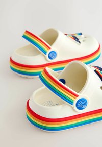 Baltas gumijas koka zābaki ar daudzkrāsainu varavīksnes akcentu uz zolītes un siksniņas, aprīkoti ar apaļām zilām dekorācijām un ventilācijas caurumiem.