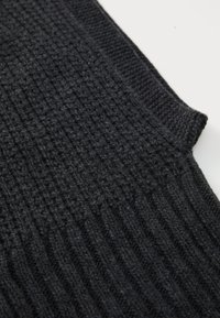Black knitted fabric with a textured ribbed design, featuring a smooth edge and varying depths in the pattern. Soft, medium-weight material.
