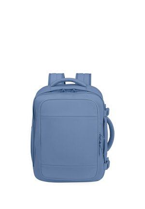 Square-shaped blue backpack with padded shoulder straps, top and side handles, and a front zippered pocket on a white background.