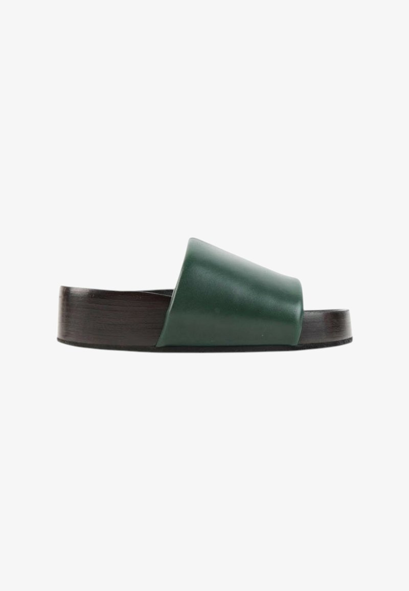 Sandale slide vert foncé unique avec une large bride en cuir et une semelle noire épaisse, vue de côté sur fond blanc.